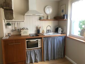 a kitchen with a sink and a microwave at LA PETITE BRETONNE in Noyal-Muzillac