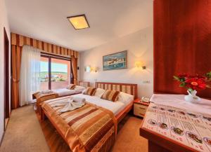 a hotel room with two beds and a window at Hotel Trogirski Dvori in Trogir