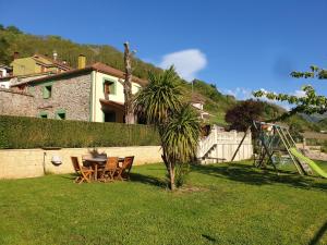 un patio con tavolo e sedie in un cortile di Habitaciones - La Pumarada de Limés II a Cangas del Narcea