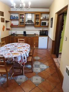 cocina y comedor con mesa y sillas en Habitaciones Pumarada 2, en Cangas del Narcea