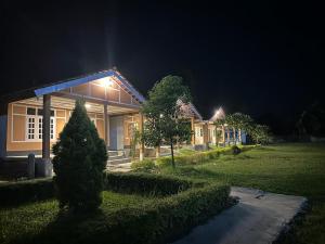 Una casa de noche con luces encendidas. en Camp Buffalo Retreat, en Jyoti Gaon