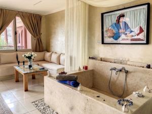 uma casa de banho com banheira e um sofá num quarto em Dar De Santis em Azamor