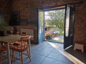 a room with a table and chairs and a sliding glass door at CASA COLOMBA in Santa Colomba de Somoza