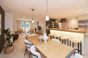 uma cozinha e sala de jantar com uma mesa de madeira e cadeiras em The Brimmington Park Escape - Lovely 3BDR House with Study Room + Garden em Londres