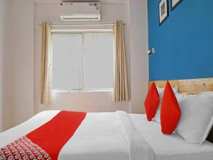 una camera da letto con un letto con cuscini rossi e una finestra di OYO Flagship 84826 Hotel Silver Key a Méribel Village