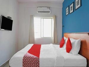 una camera con un letto con una coperta rossa e bianca di OYO Flagship 84826 Hotel Silver Key a Méribel Village