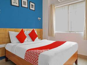 una camera da letto con un letto con cuscini rossi e bianchi di OYO Flagship 84826 Hotel Silver Key a Méribel Village