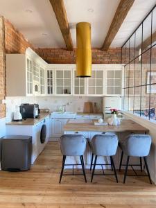 a kitchen with white cabinets and a wooden table and chairs at Apartments PSD - Anny Łajming 2B in Słupsk