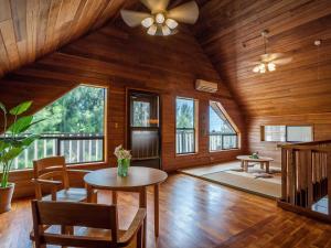 een woonkamer met een plafondventilator en een tafel bij Kariyushi Condominium Resort Yuudekiya in Onna