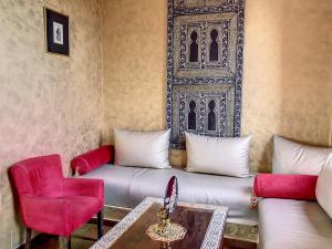 un soggiorno con divano e sedie rosse di Dar De Santis a Azemmour