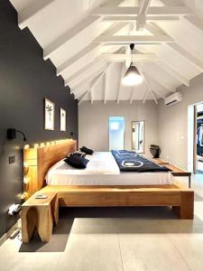 Saint Barthelemy的住宿－Villa des Vents，一间卧室配有一张大床和木制床头板