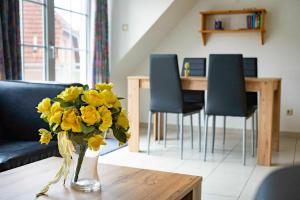 een woonkamer met een vaas met gele bloemen op een tafel bij Ferienwohnung Krebs in Hooksiel