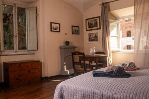 a bedroom with a bed and a table and a window at Palazzo Micheletti Lucca in Lucca