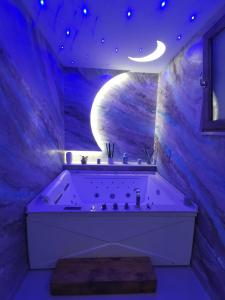 卡斯特拉玛雷帝斯达比亚Le Stanze di Eli e Giò的紫色浴室设有浴缸和月亮
