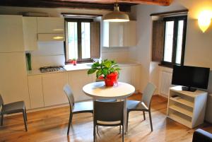 a kitchen with a table and chairs and a kitchen with a table and a plant at Il Borgo Antico in Cadarese