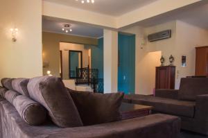 un soggiorno con un divano e un tavolo di Leone Luxury Villas a Kalamákion