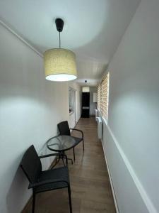 um corredor com cadeiras, uma mesa e uma luz em Casa Elena, Ocna Mureș em Ocna Mureş