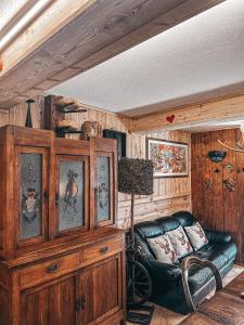 un soggiorno con divano in pelle e pareti in legno di Le Grenier de Olga e Mario a Pré-Saint-Didier