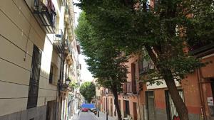 wąska ulica z budynkami i samochodem w obiekcie Sol Apartamento Madrid Centro w Madrycie