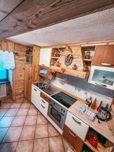 La cuisine est équipée de placards en bois et d'un four avec plaques de cuisson. dans l'établissement Le Grenier de Olga e Mario, à Pré-Saint-Didier