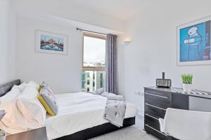 a white bedroom with a bed and a window at Panoramic Pad with Free Parking - By My Getaways in Brighton & Hove