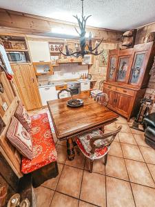 a kitchen with a wooden table and chairs at Le Grenier de Olga e Mario in Pré-Saint-Didier
