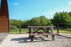 a picnic table sitting next to a fence at Wyreside Lakes Glamping Pods in Lancaster