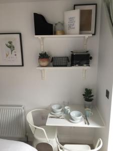 een kleine keuken met een witte tafel en stoelen bij Cedar Shade Cottage Ensuite Private Annexe with Parking in Sidmouth
