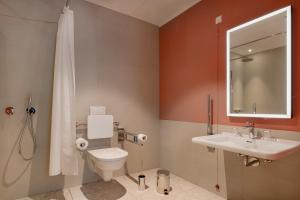 a bathroom with a toilet and a sink and a mirror at Elisapart - Apartments am Sommerschloss in Potsdam +31 photos