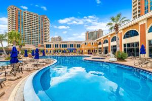 a pool at the resort with chairs and umbrellas at 5 Portofino 1106 at Pensacola Beach in Pensacola Beach