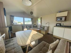 ein Wohnzimmer mit einem Tisch und einem Sofa in der Unterkunft Superb 6 Berth, Dog Friendly Caravan For Hire By The Beach In Norfolk Ref 50008m in Great Yarmouth