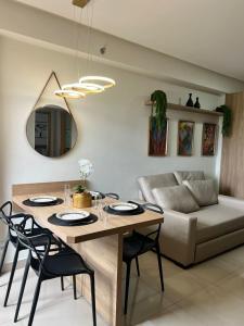 uma sala de estar com uma mesa com cadeiras e um sofá em Flat Super Luxo - Rio Quente - Acesso Ao Rio em Rio Quente