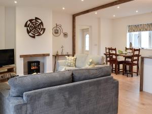 een woonkamer met een bank en een open haard bij Spring Cottage in Kentisbury