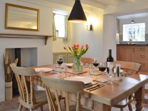 a dining room with a wooden table with wine glasses at Sunny Cottage in Bulmer