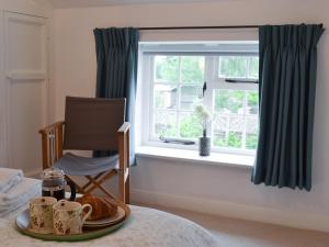 a plate of croissants and coffee cups on a table next to a window at Sunny Cottage in Bulmer