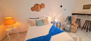 een slaapkamer met een bed, een lamp en een stoel bij Estância Villa Ventura in Socorro