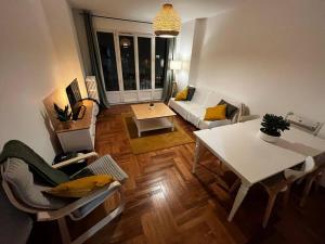 ein Wohnzimmer mit einem weißen Tisch und einem Sofa in der Unterkunft 4 personnes - ambiance cosy - proche universités in Grenoble