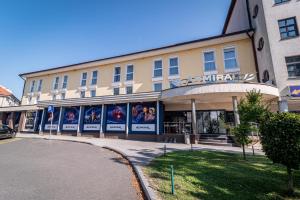 un bâtiment avec des affiches sur son côté dans l'établissement Casino & Hotel ADMIRAL Ptuj, à Ptuj