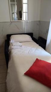 - un lit blanc avec un oreiller rouge dans l'établissement Tourist House Bologna - Self check-in, à Bologne