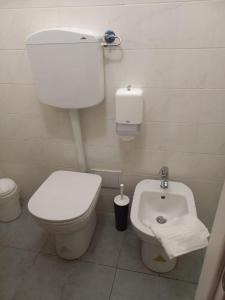 La petite salle de bains est pourvue de toilettes et d'un bidet. dans l'établissement Tourist House Bologna - Self check-in, à Bologne