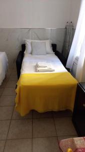 - un lit jaune avec 2 oreillers au-dessus dans l'établissement Tourist House Bologna - Self check-in, à Bologne