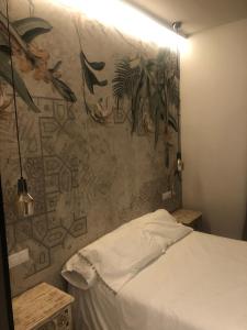 1 dormitorio con 1 cama y una pared con un mural en TRIANA INES, en Sevilla
