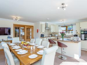 a kitchen and dining room with a wooden table and chairs at The Lookout in Aviemore