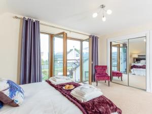 a bedroom with a bed and a large window at The Lookout in Aviemore