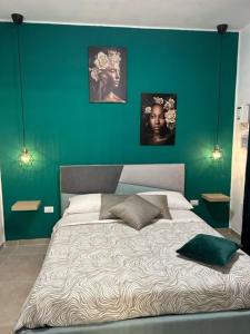 1 dormitorio con 1 cama grande y pared verde en L'antica finestra verde en Marsala