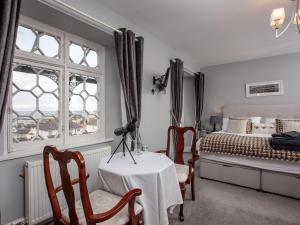 a bedroom with a bed and a table and chairs at Ranscombe House in Brixham