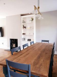 a dining room with a wooden table and chairs at Dove View Hartington: luxury 3 bed cottage in Hartington