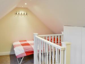 a childs room with a crib and a staircase at Sycamore Cottage in Consett