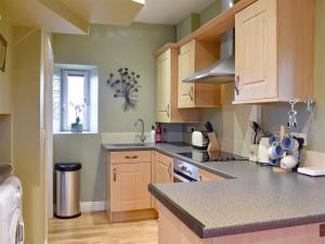 a kitchen with wooden cabinets and a counter top at Sycamore Cottage in Consett