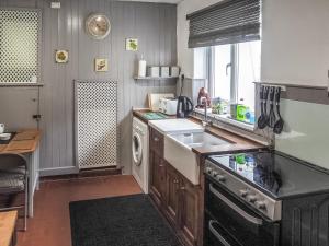 a kitchen with a sink and a dishwasher at Meredith Cottage in Dolwyddelan
